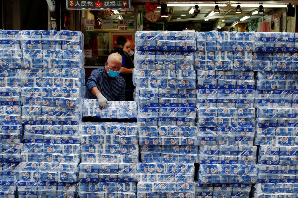 A masked employee restocks toilet paper at a shop on February 8, following the panic buying of masks and toilet rolls in Hong Kong. Photo: Reuters