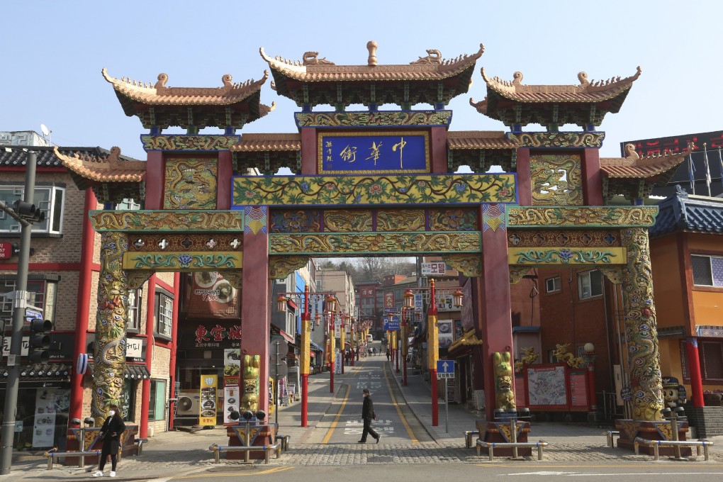A man wearing a faces mask passes by the main entrance gate to Chinatown in Incheon, South Korea, on Friday. Photo: AP