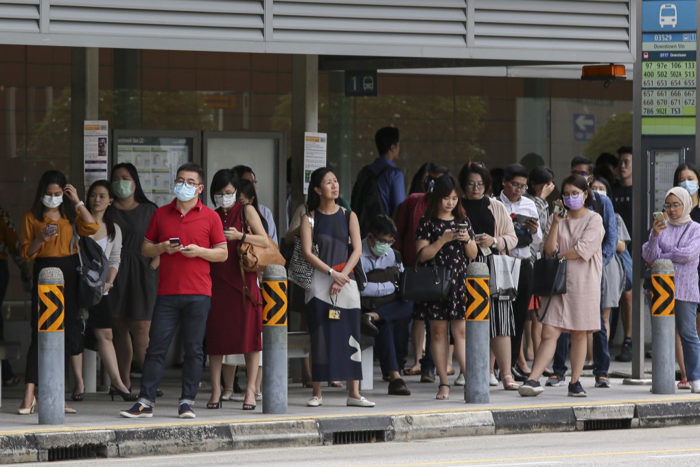 Commuters at a bus stop in the Marina Bay business district in Singapore. Photo: Bloomberg