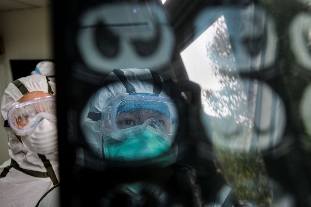 Medical workers in protective suits check a CAT scan image of a patient at a community health service centre in Wuhan, Hubei province. Photo: China Daily via Reuters