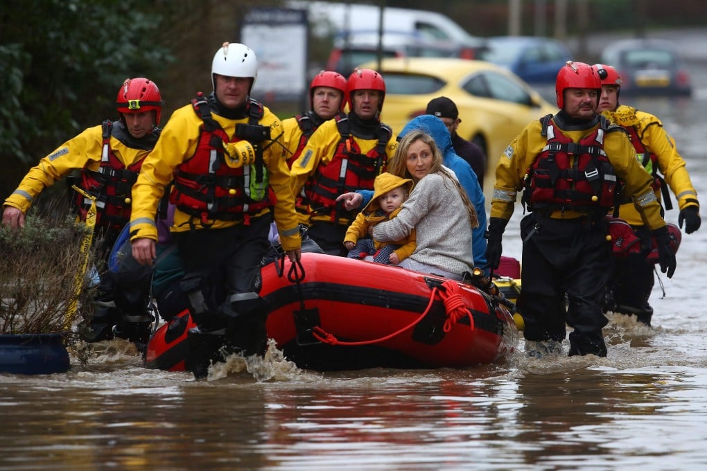 Members of the emergency services evacuate residents from flooded houses after the River Taff burst its banks in Nantgarw, south of Ponypridd in south Wales, after Storm Dennis caused flooding across large swathes of Britain. Photo: AFP