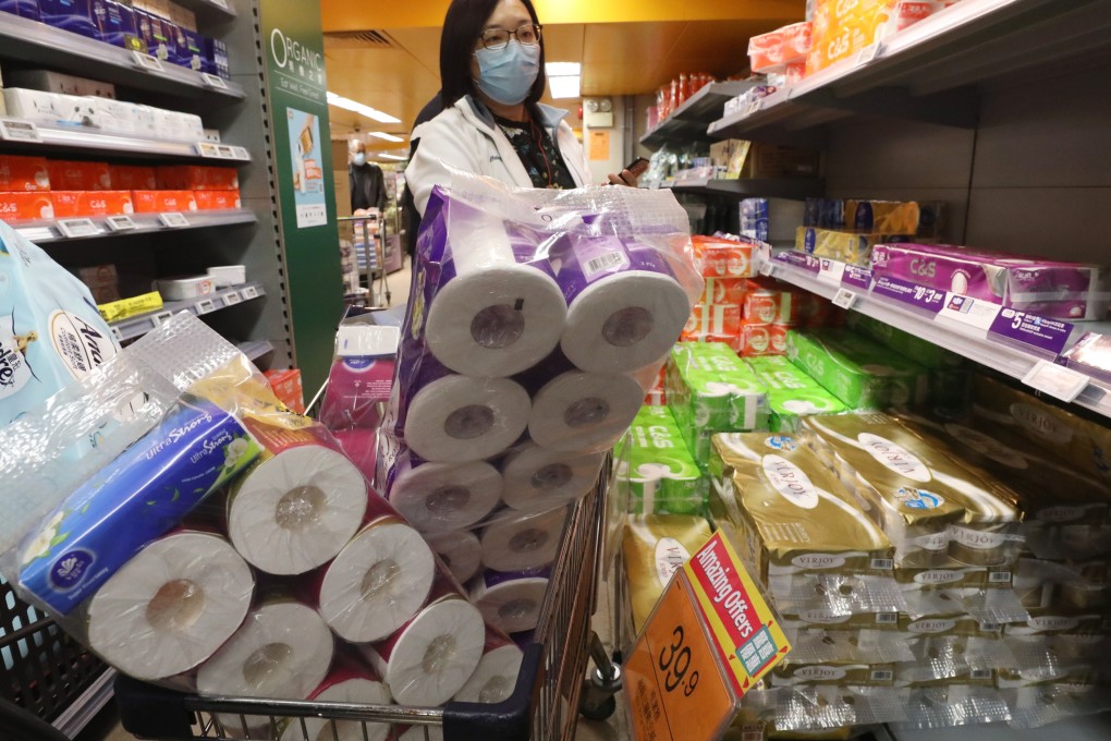 A shopper with a cart brimming with toilet rolls. Photo: Nora Tam