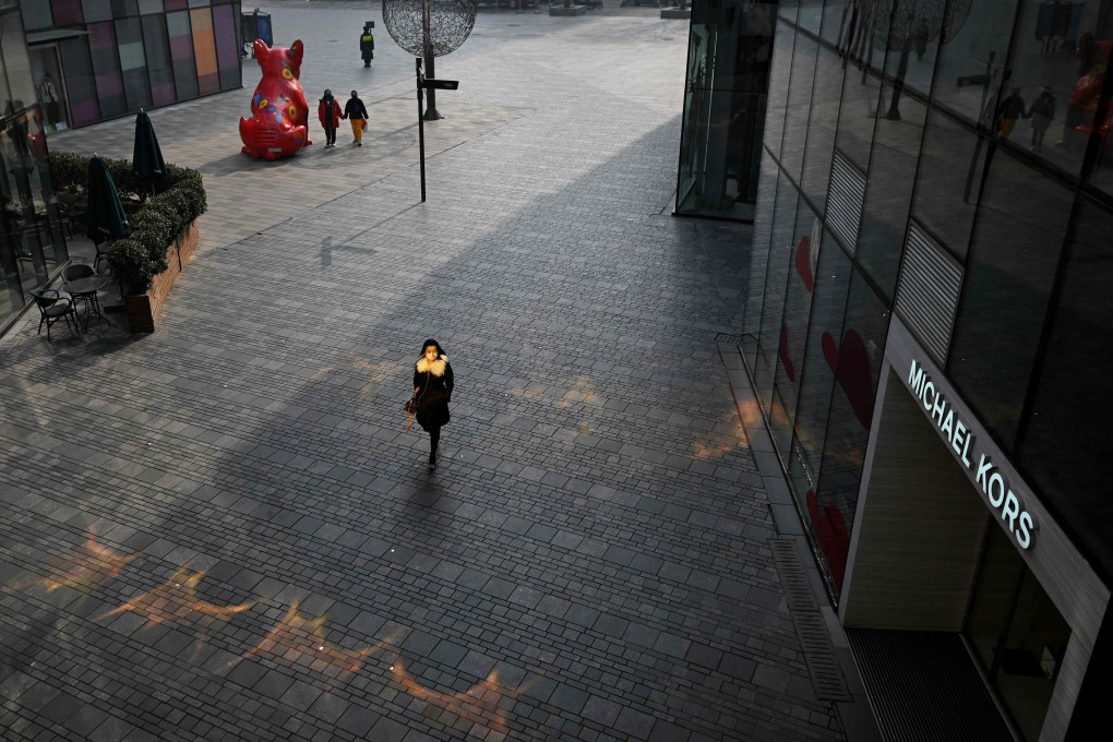 A woman walks through a deserted shopping mall in Beijing. Photo: AFP