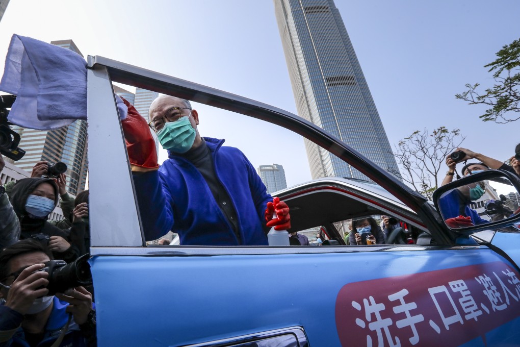 Secretary for Transport and Housing Frank Chan Fan helps disinfect a taxi at February 17 event to promote protective measures during the coronavirus outbreak. Photo: Felix Wong