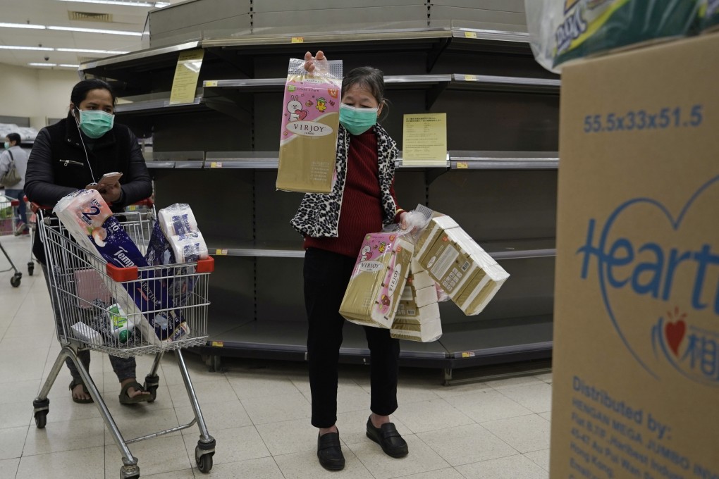 Customers wearing masks scramble for tissue paper in front of empty shelves in a supermarket in Hong Kong on February 8. Photo: AP