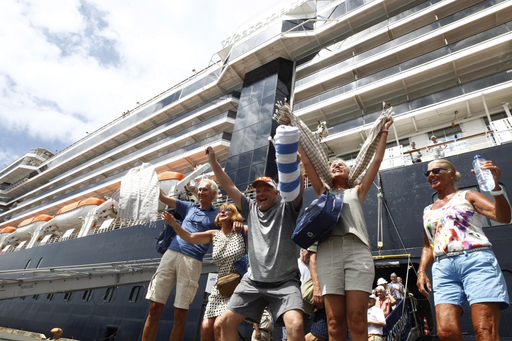 Passengers disembarking from the MS Westerdam at Sihanoukville in Cambodia on Friday, February 14, 2020. Hundreds of cruise ship passengers long stranded at sea by virus fears cheered as they finally disembarked Friday and were welcomed to Cambodia. Photo: AP