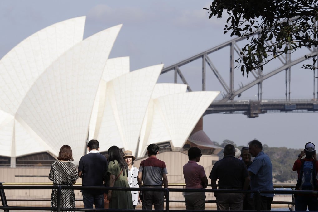 In this January 22, 2020, photo, tourists gather to have their photos taken with the Opera House and Harbour Bridge as a backdrop in Sydney, Australia. Photo: AP