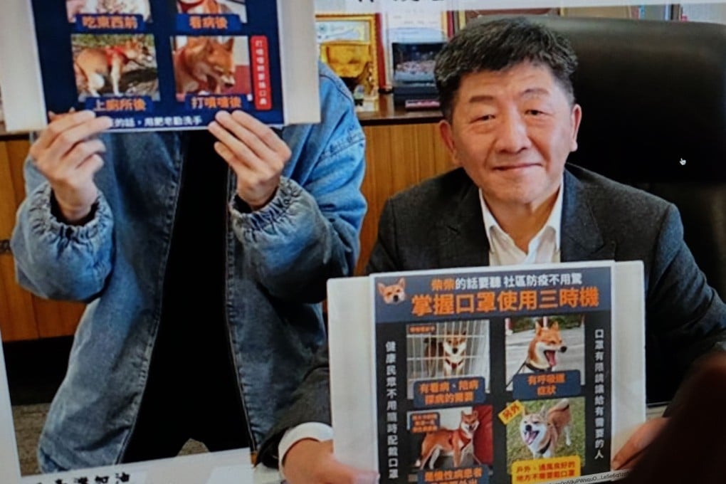 Taiwan’s Health Minister Chen Shih-chung holds a placard on virus prevention featuring Zongchai, the ministry’s “spokesdog”. Photo: AFP