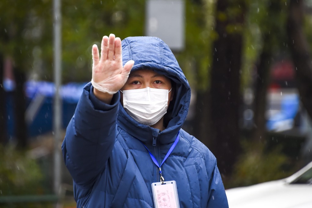 An official stops a car to check temperatures in Xiaogan on Friday. The city has taken the unprecedented step of confining people to their homes. Photo: Xinhua