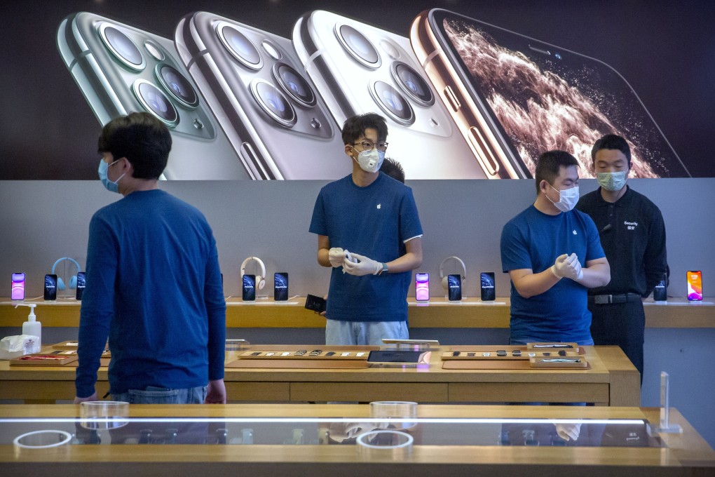 Employees wear face masks as they stand in a reopened Apple Store in Beijing on Friday. Photo: AP