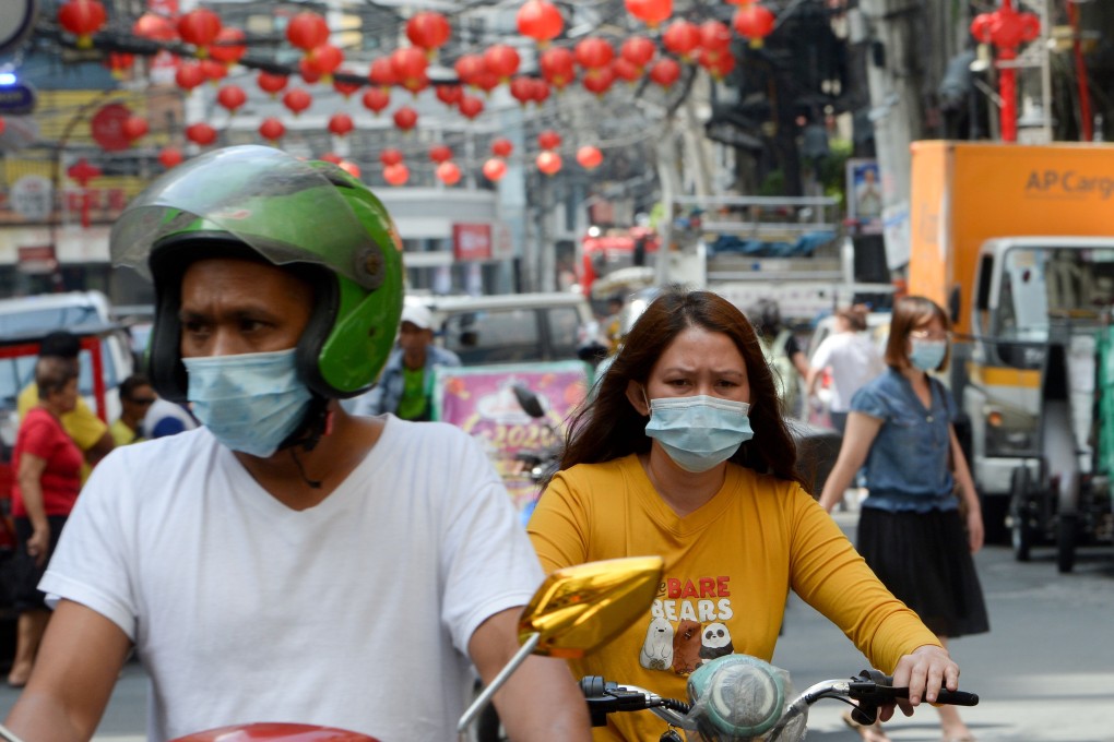 Motorists wearing face masks making their way along a street in Manila’s Chinatown district of Binondo. Photo: AFP