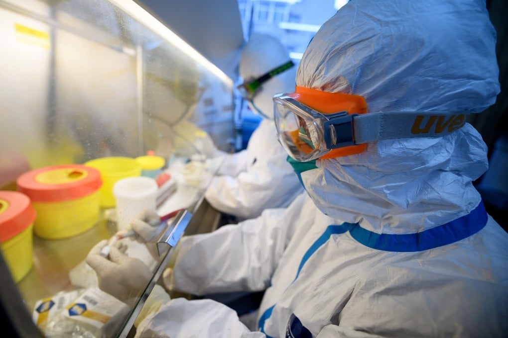 Workers in protective suits test coronavirus specimens inside a laboratory at a centre for disease control and prevention in China. Photo: Reuters