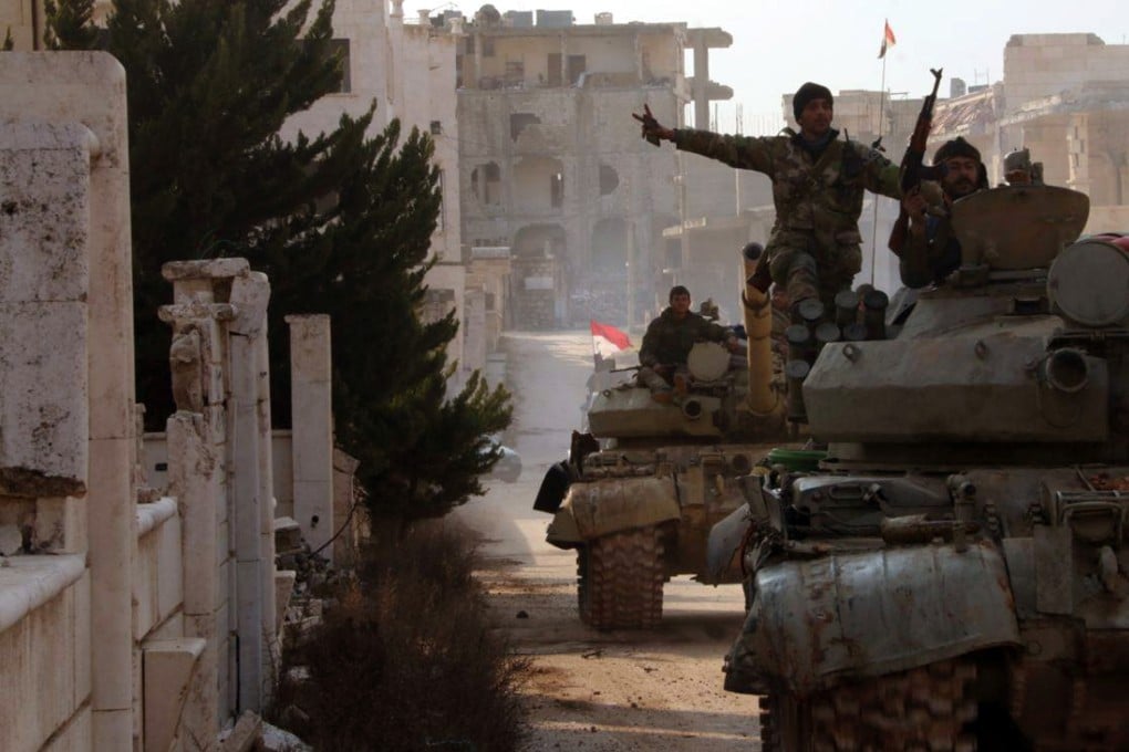 Syrian soldiers gesture in town of Kafar Hamra, in Syria’s Aleppo province, in an image released on Monday. Photo: SANA via Reuters