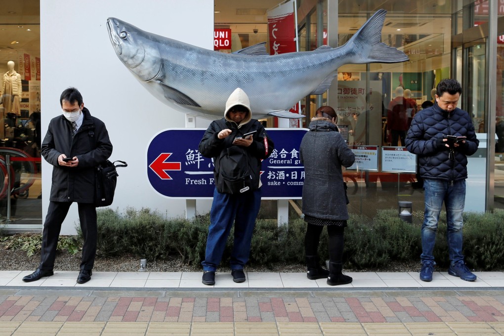 People use their smartphones on a street in Tokyo. A new bill approved by Japan’s cabinet shows how policymakers are alarmed over China’s influence in 5G mobile technology development. Photo: Reuters