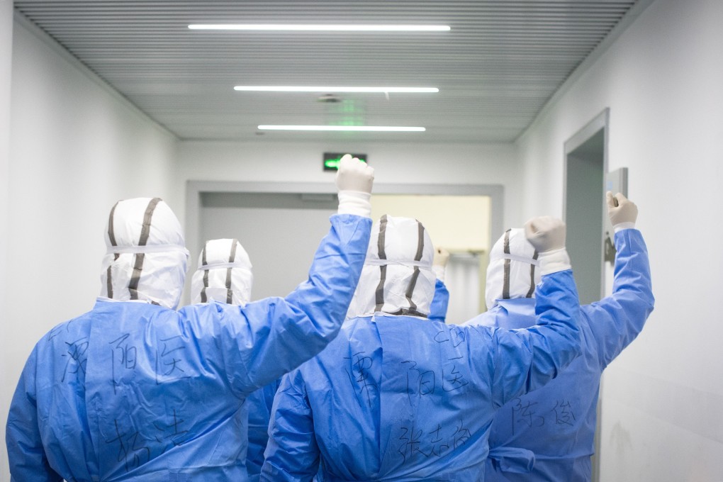 Medical workers try to lift their spirits by cheering for each other before entering a temporary hospital set up at Wuhan Sports Centre in Wuhan, Hubei province. Photo: Xinhua