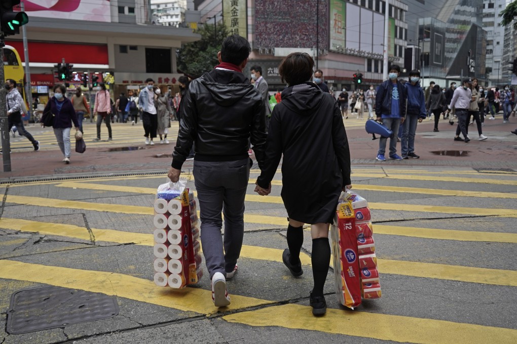 A couple carry rolls of toilet paper on February 14, Valentine’s Day, in Hong Kong. Photo: AP