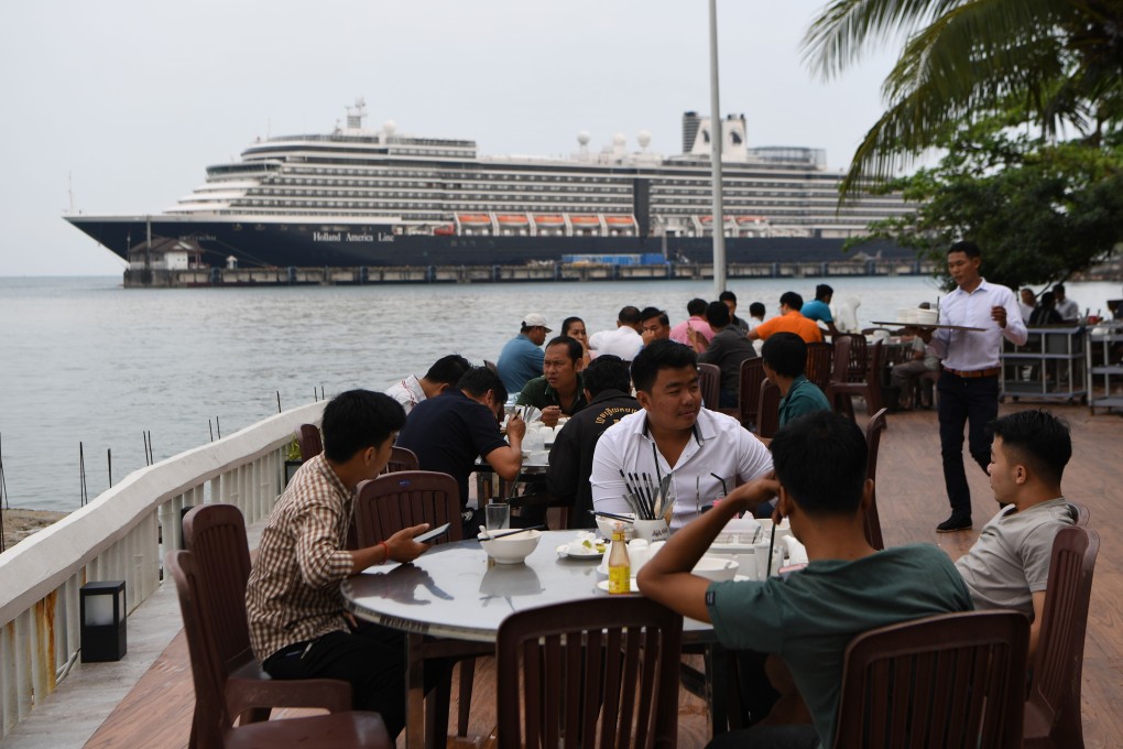 People sit at a restaurant in front of the Westerdam cruise ship in Sihanoukville on February 19, 2020. Photo: AFP