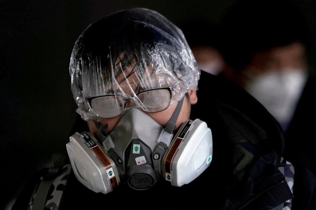 A man outside the Shanghai railway station wears a mask and other protective gear. Photo: Reuters