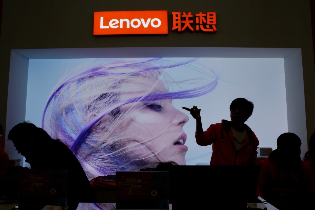 A Lenovo Group employee gestures next to the company’s logo at an event in Beijing in November of last year. Photo: Reuters
