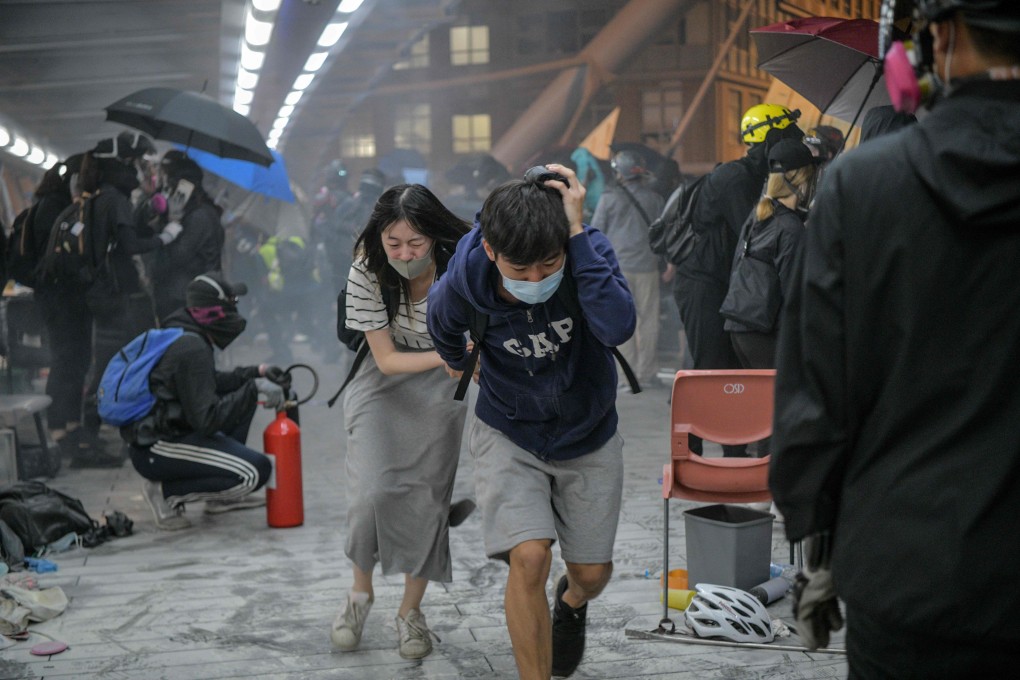 Protesters run for cover after riot police fire tear gas outside Polytechnic University, in Hung Hom, in November. Photo: AFP
