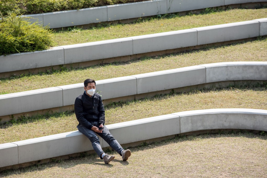 A man wearing a protective mask sits in a park in Hong Kong on February 20. Photo: Bloomberg