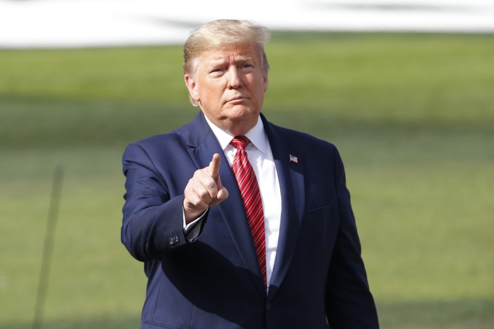 US President Donald Trump gestures to car crews and fans before the start of the Daytona 500 race in Florida on Sunday. Photo: AP