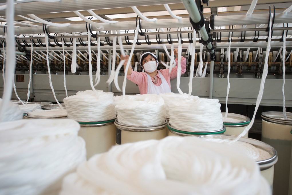 An employee wearing a face mask works on a production line at a textile factory in Haian, Jiangsu province. Photo: Reuters