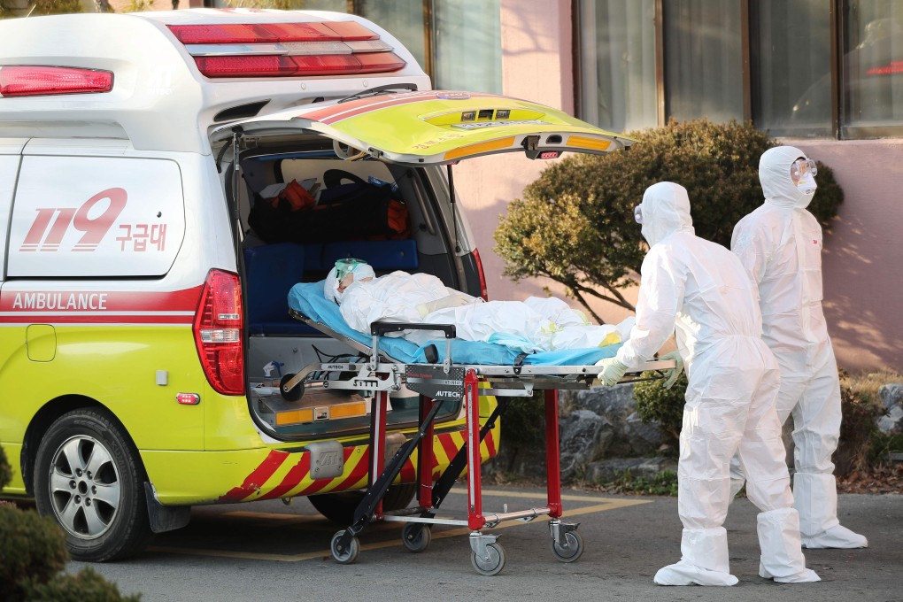 Medical workers wearing protective gear transfer a suspected coronavirus patient to another hospital, in Cheongdo county near the southeastern city of Daegu. Photo: AFP