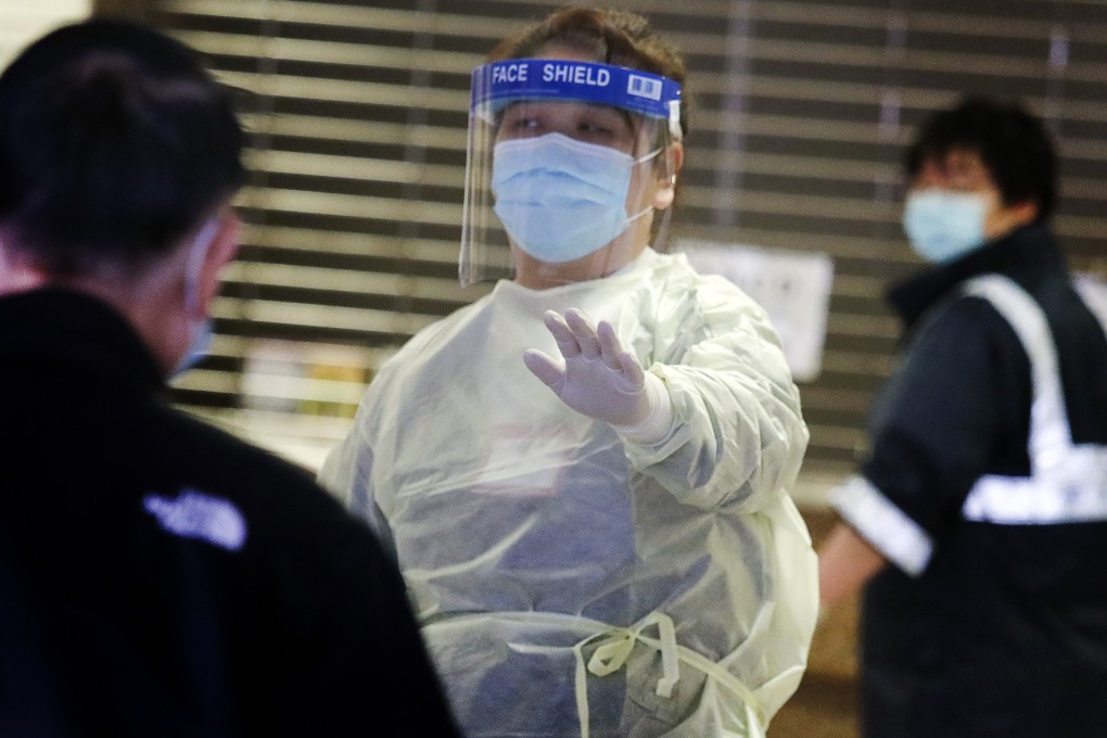 A fully masked hospital staff member stops visitors from entering Queen Elizabeth Hospital in Jordan. Photo: Nora Tam