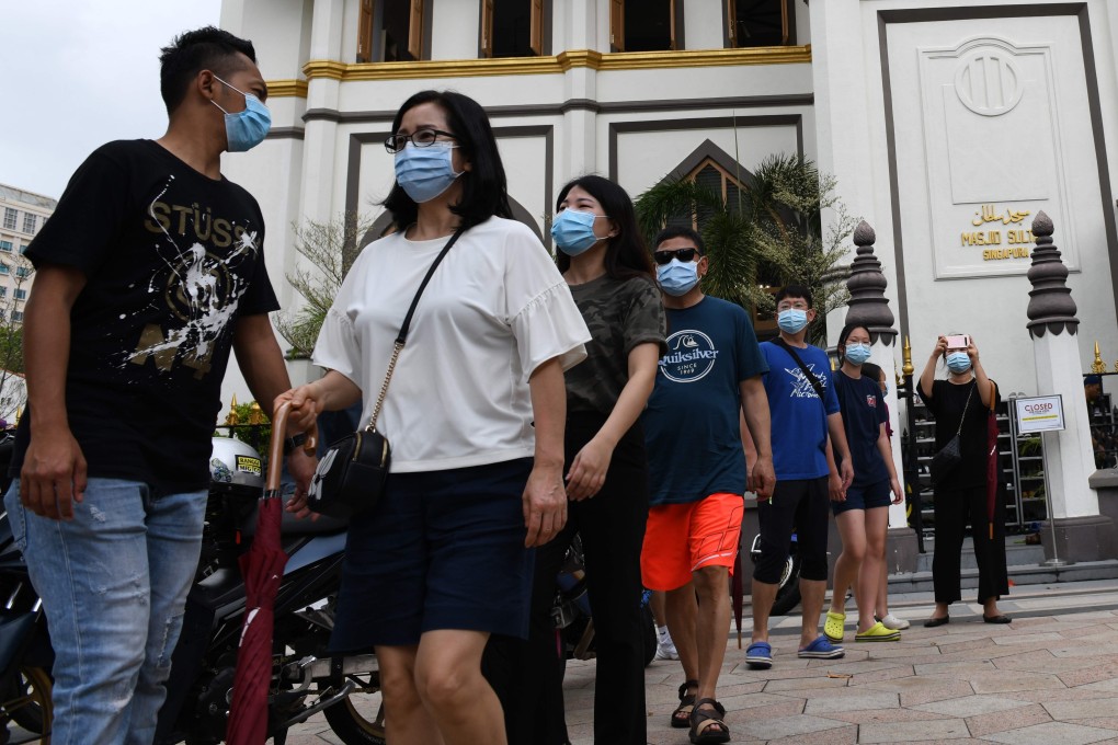 Visitors wearing face masks walk past a mosque in Singapore. Photo: AFP