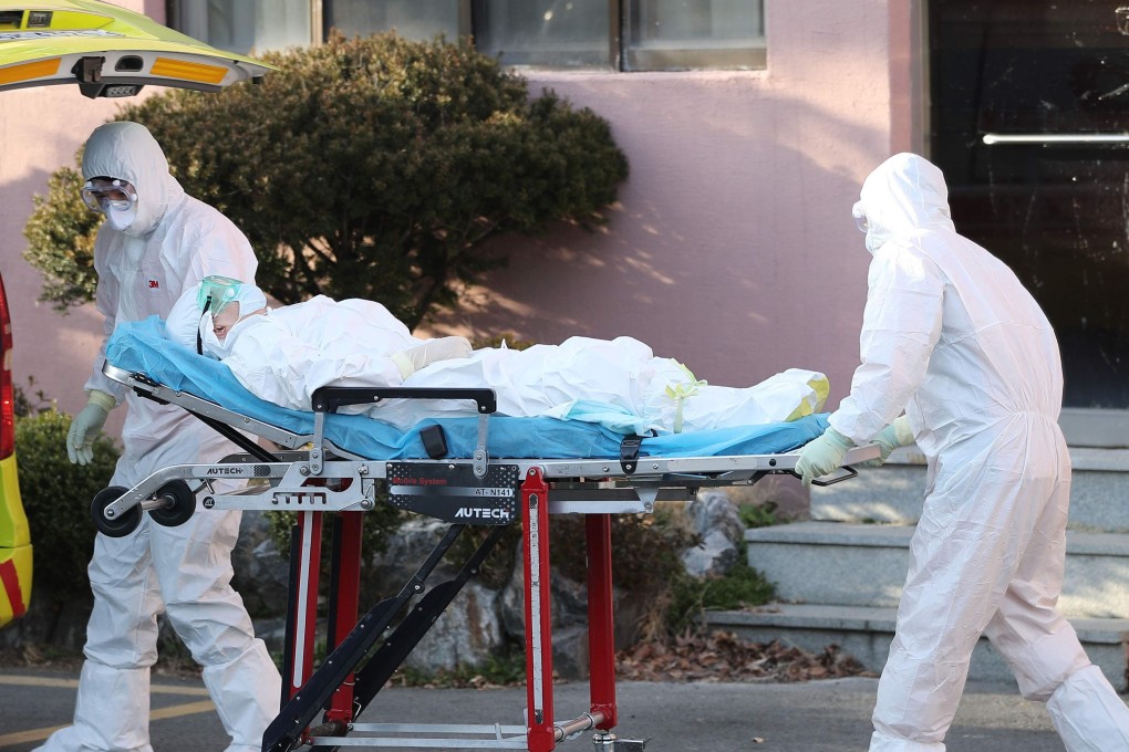 Medical workers wearing protective gear transfer a suspected coronavirus patient to another hospital from Daenam Hospital in Cheongdo county near the southeastern city of Daegu. Photo: AFP