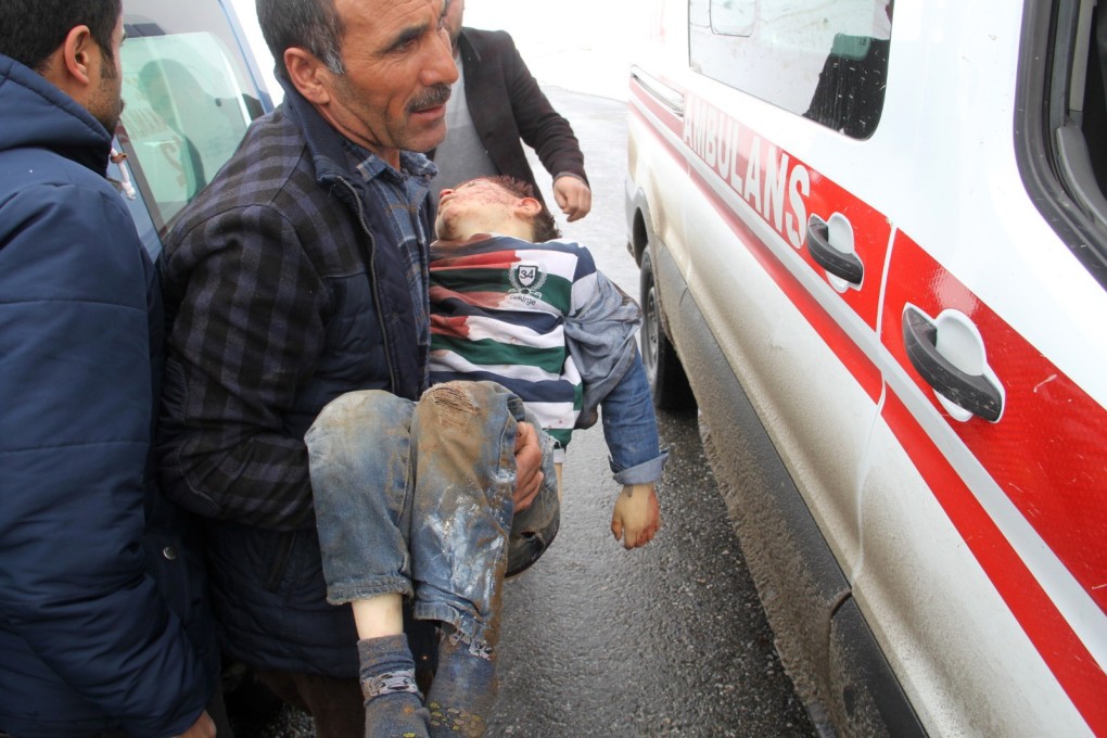 A man carries a wounded boy to an ambulance after an earthquake hit villages in Baskale town, Van province, Turkey, on Sunday. Photo: AP