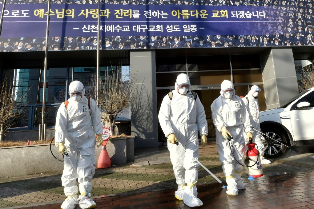 South Korean health officials disinfect an area in front of the Daegu branch of the Shincheonji Church of Jesus. Photo: Handout / AFP