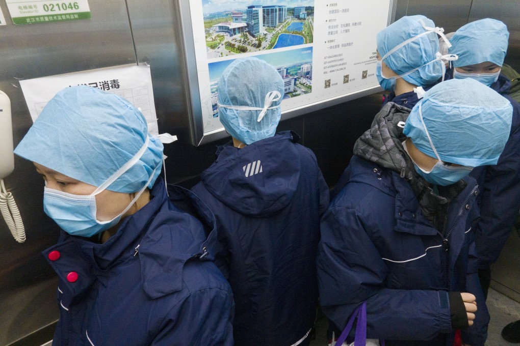 Workers in a lift at Tongji Hospital in Wuhan, China, face in different directions to prevent cross-infection. Photo: Xinhua