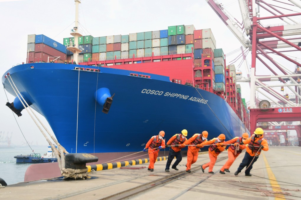 Workers wearing face masks helping a container ship to its berth at Qingdao port in Shandong province on February 11, 2020. Photo: China Daily via Reuters