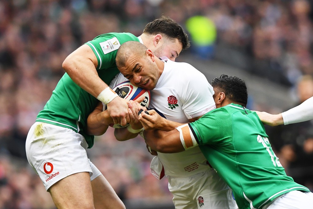 Ireland’s Bundee Aki (right) tackles England’s Jamie George (centre) during their Six Nations match at Twickenham. Photo: EPA