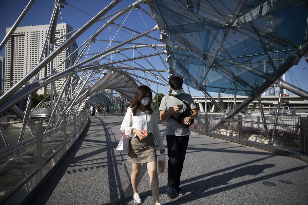 People wearing face masks walk along the Helix Bridge in Singapore earlier this month. Photo: EPA