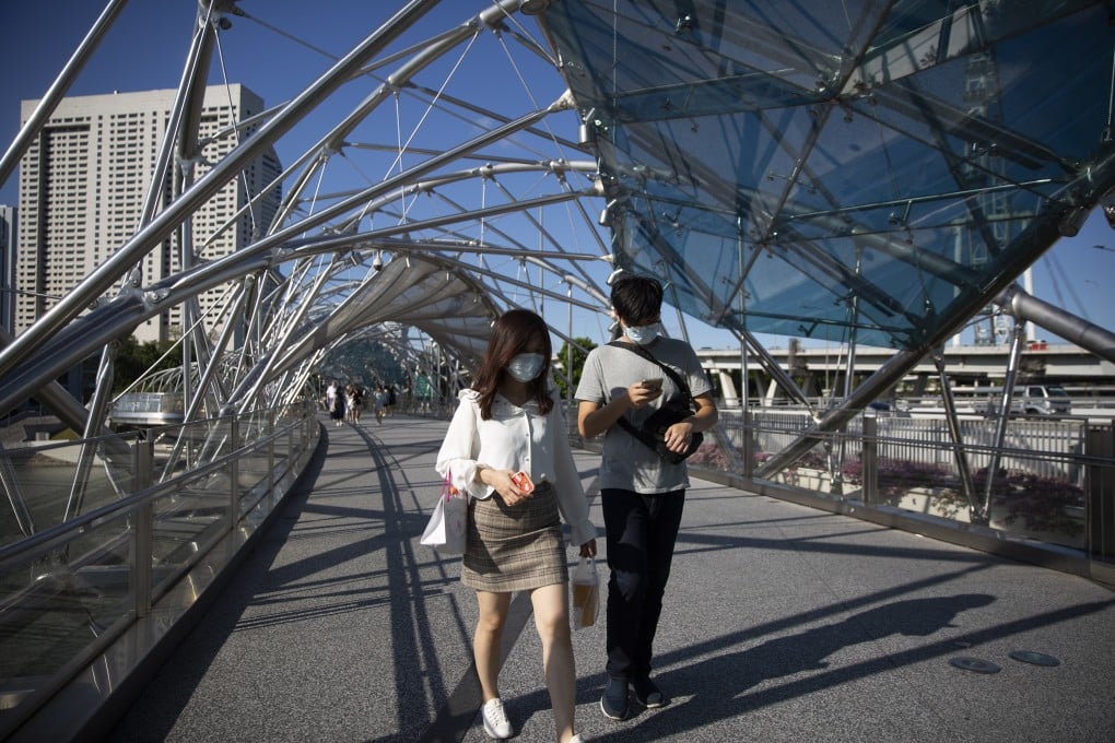People wearing face masks walk along the Helix Bridge in Singapore earlier this month. Photo: EPA