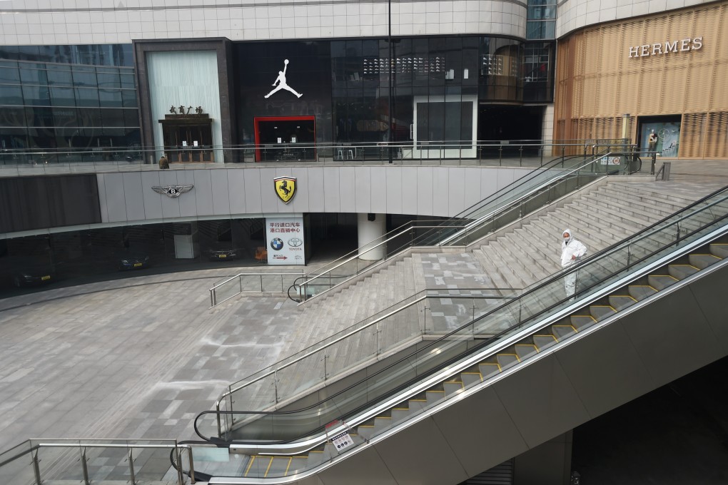 A man in protective suit stands at a shopping centre in Wuhan, the epicentre of the novel coronavirus outbreak, Hubei province, China on Tuesday. Photo: Reuters