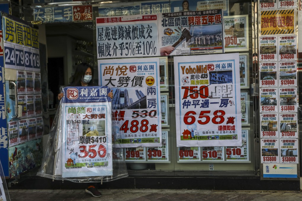 A property agency staff set the advertising board in front of the shop in Yuen Long on 17 February 2020. Photo: KY Cheng