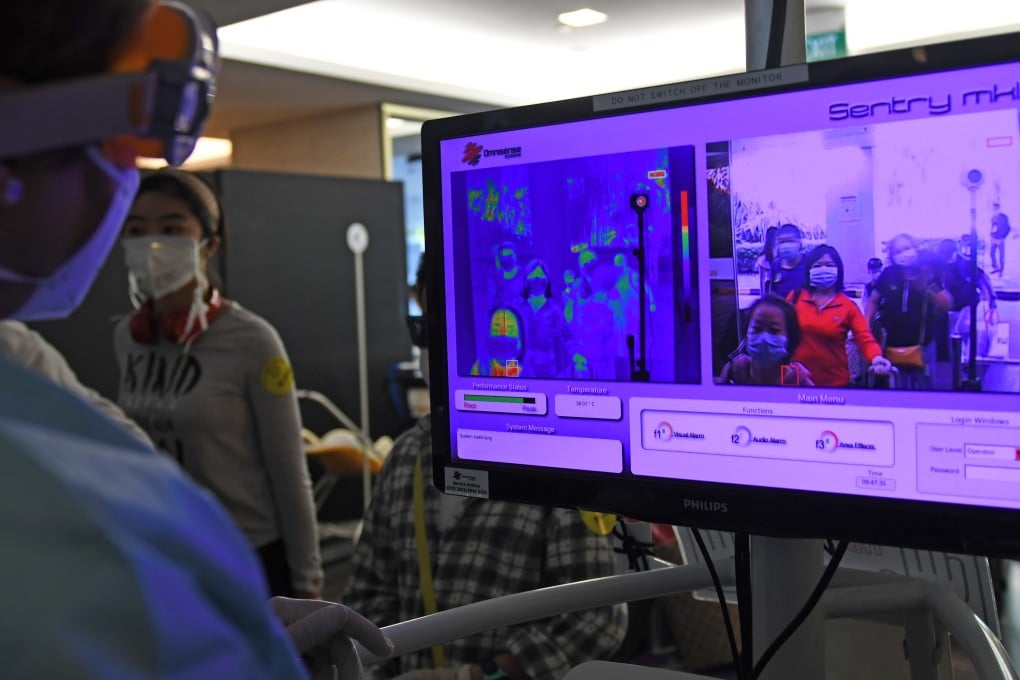 A staff member checks the body temperatures of passengers at Singapore Changi Airport on February 5, 2020. Photo: Xinhua