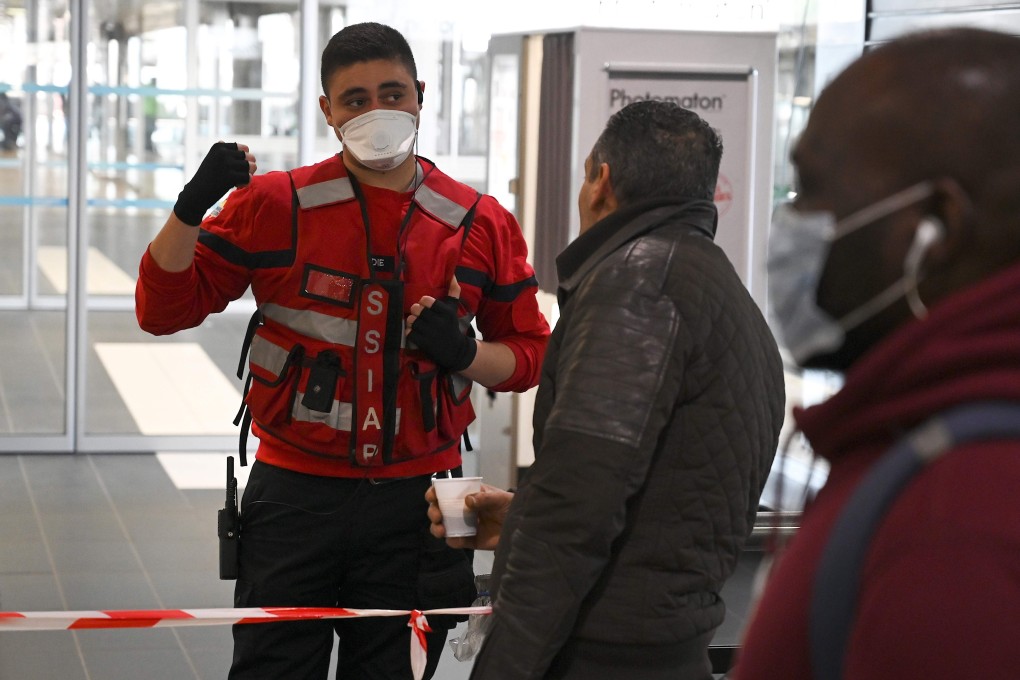A member of French emergency services directs travellers at a transport interchange where a bus carrying a possible virus carrier was discovered. Photo: AFP