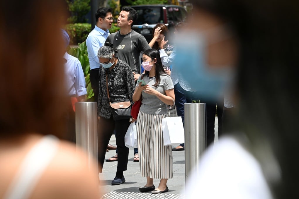 Pedestrians wearing face masks as a preventive measure against the spread of coronavirus wait to cross a road in Singapore on Wednesday. Photo: AFP