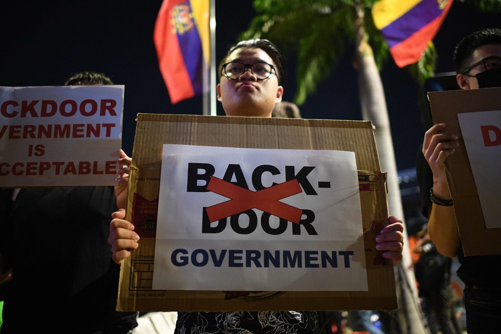 A man holds a sign at a protest against a national government being formed without new elections at Independence Square in Kuala Lumpur. Photo: AFP