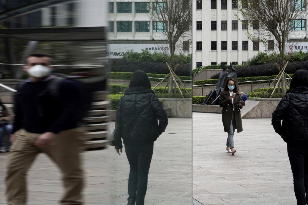 People in protective masks in Central, the main business district of Hong Kong, where rental rates for commercial property have plummeted. Photo: AP