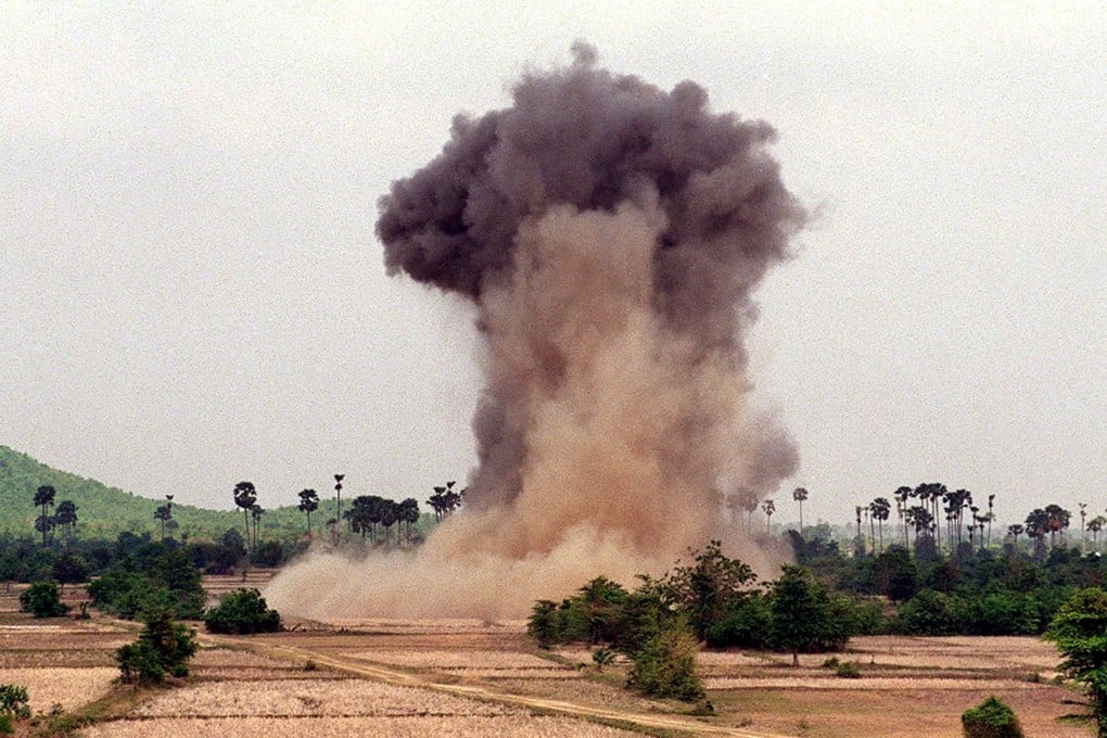 A cloud of dust and smoke rises into the sky as deminers from the Cambodian Mine Action Centre, with the help of non-governmental organisation Halo Trust, explode landmines in the western province of Kampong Speu, Cambodia. Photo: AFP