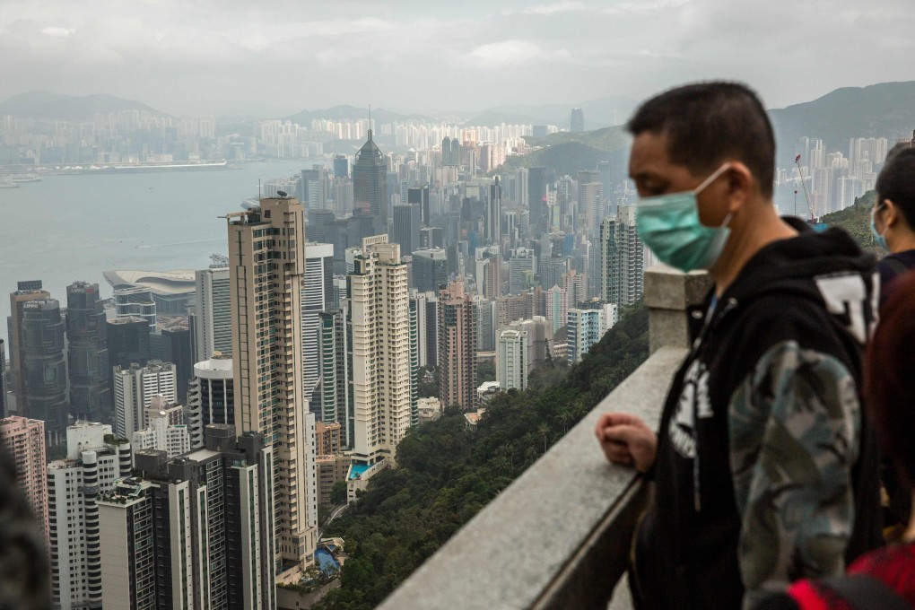 People wearing protective face masks visit the lookout of Victoria Peak on February 25. Gilead Sciences plans to expand clinical studies of remdesivir, its antiviral drug for the treatment of Covid-19, in Hong Kong, South Korea, Taiwan and Singapore. Photo: Agence France-Presse