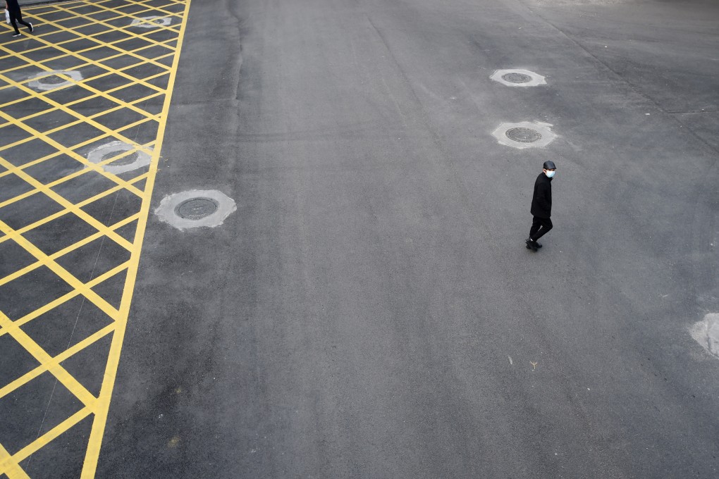 A man wearing a mask crosses a road in Wuhan, the city at the epicentre of the coronavirus outbreak, on February 24. Photo: Reuters