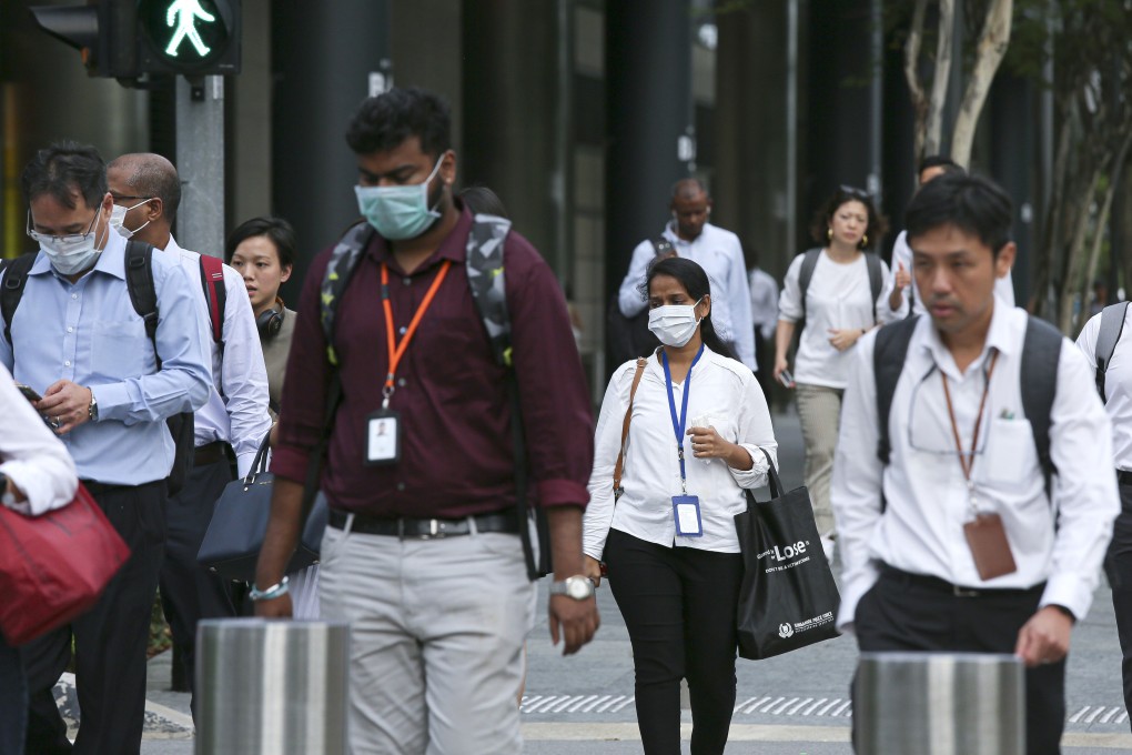 Commuters wearing protective masks at the Marina Bay business district in Singapore on Wednesday, Feb. 12, 2020. Photo: Bloomberg
