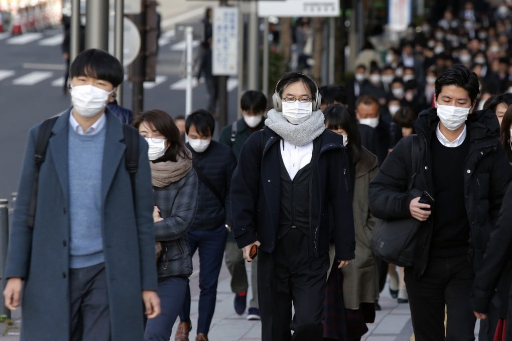 People wear masks as they commute during the morning rush hour in Chuo district. Photo: AP